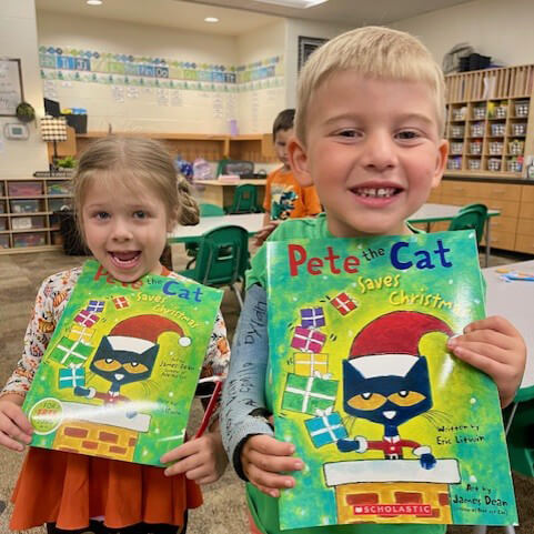 two kids holding books